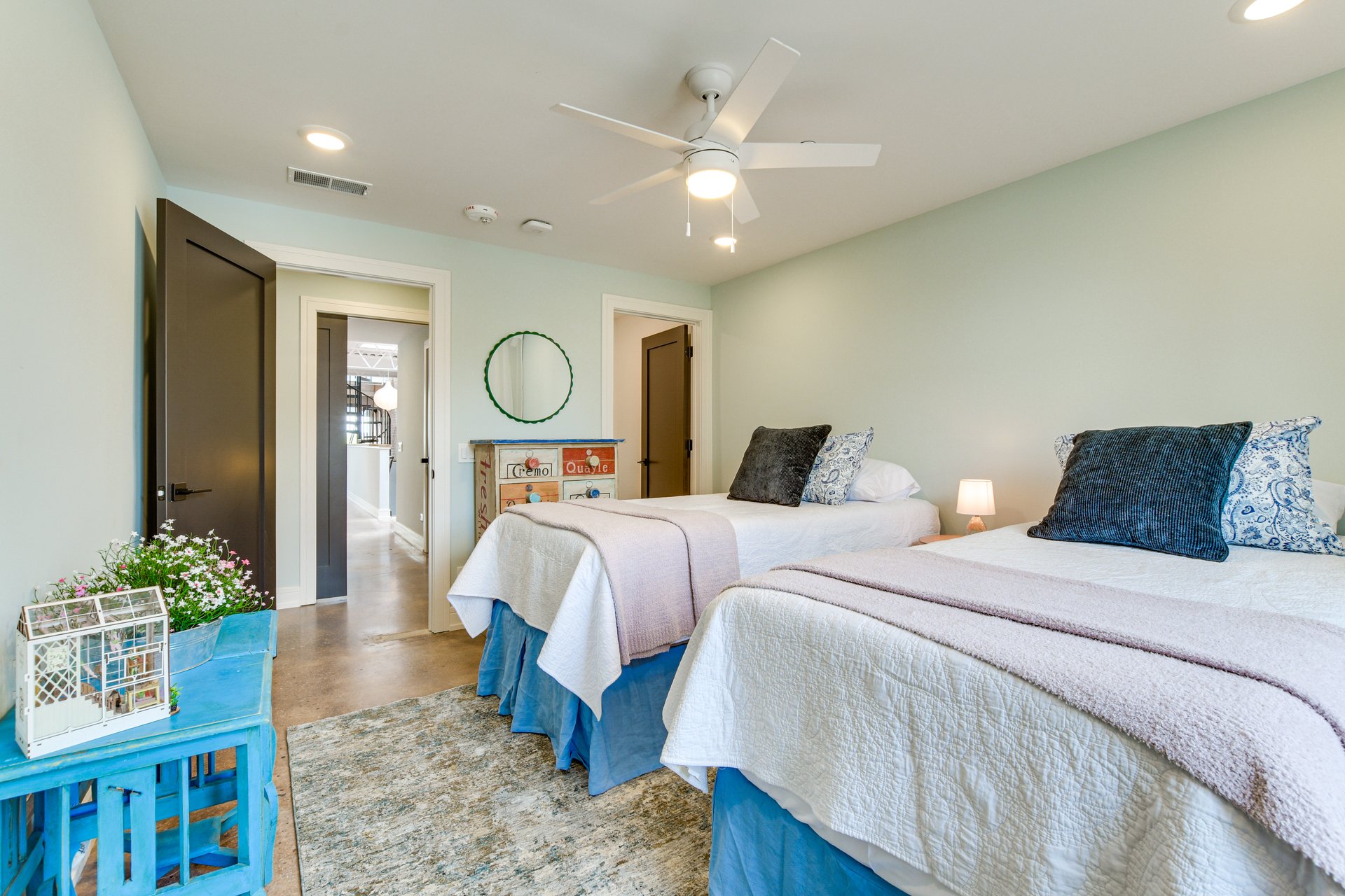 Second bedroom with two beds, soft linens, and a view down the hall