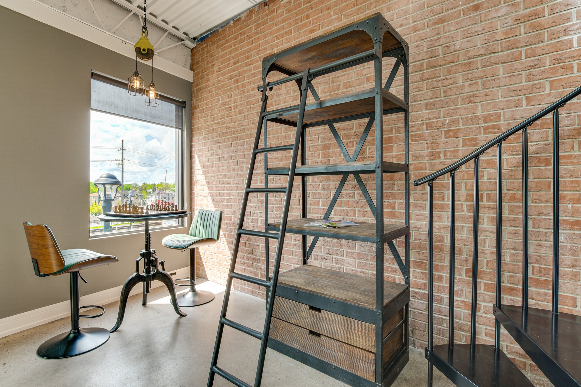 Brick-walled nook with a chess table and an industrial bookshelf