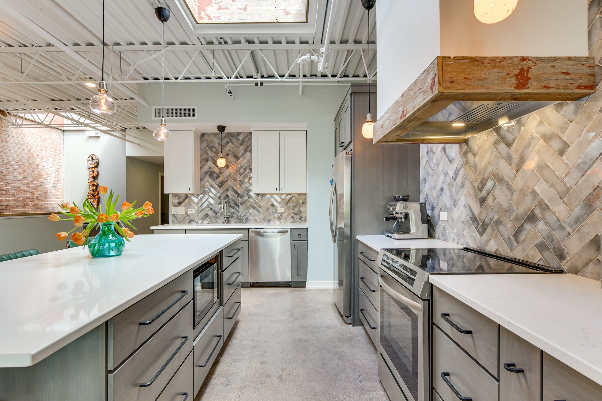 Kitchen with herringbone tile, stainless appliances, and an espresso machine