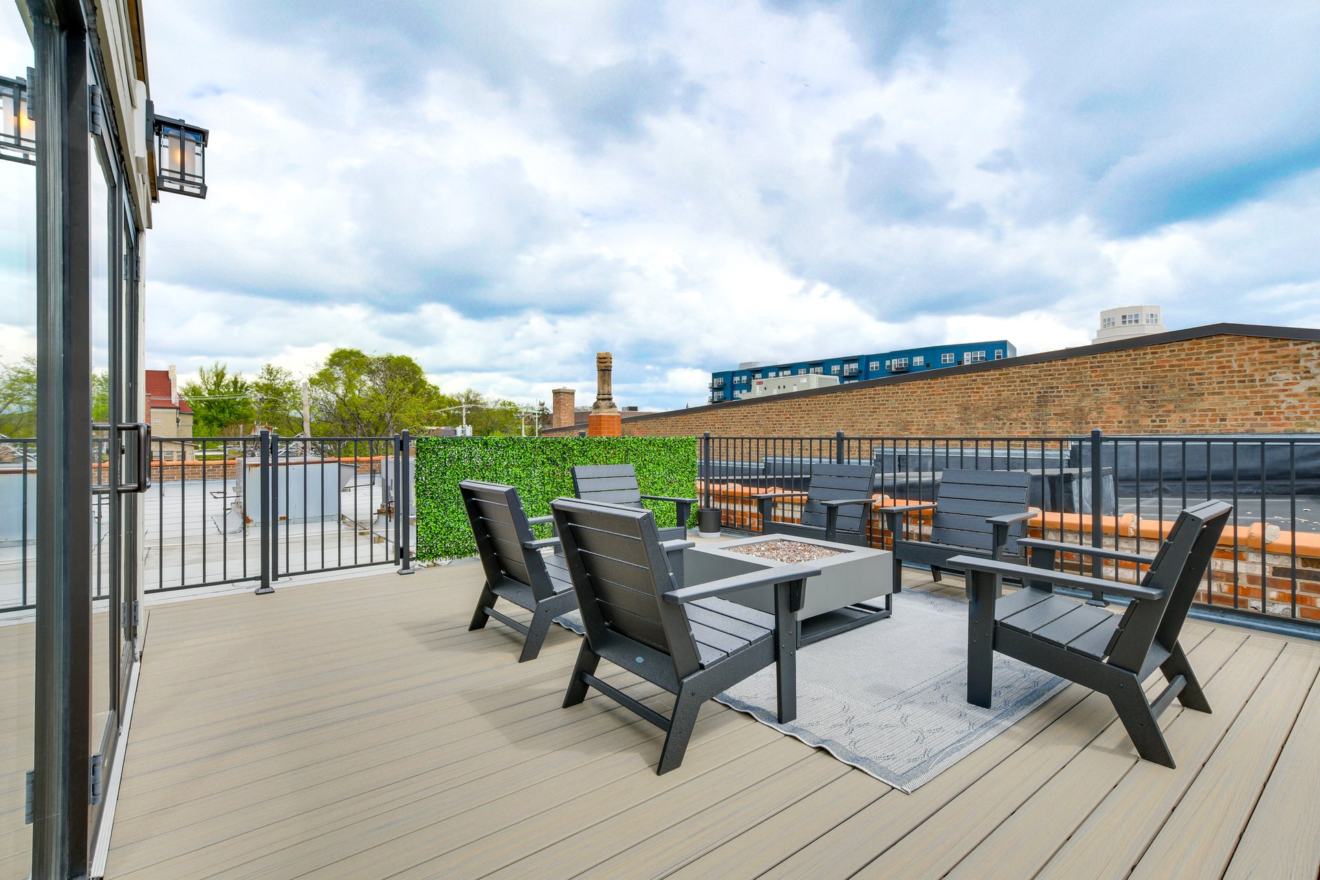 Private rooftop deck with lounge seating and a fire table